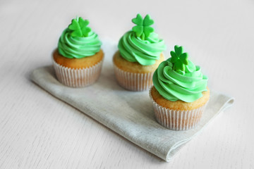Tasty cupcakes with clover on napkin. Saint Patrics Day concept
