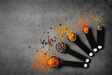 Different spices in spoons on table