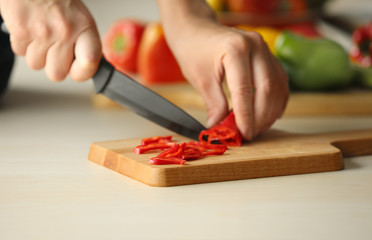 Obraz na płótnie Canvas Woman cutting pepper in kitchen