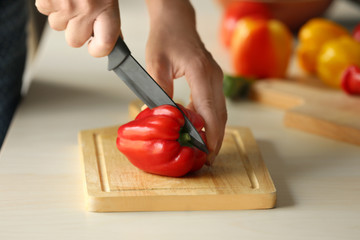 Woman cutting pepper in kitchen