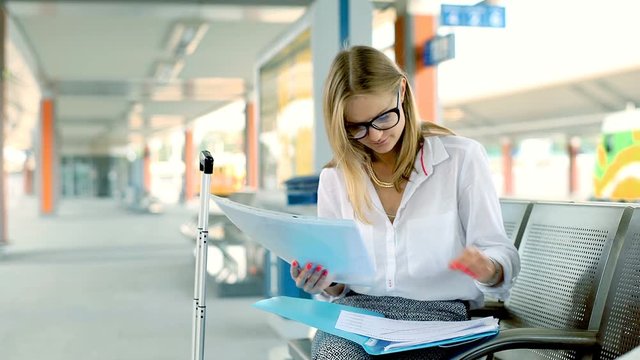 Businesswoman having a painful headache while sitting on the train station
