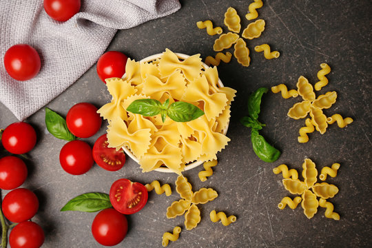 Plate with farfalle pasta and tomatoes on table