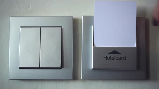 The Key to the Room - Access to the Service of the Hotel/Female hand inserts an electronic room key. Lights on. She removed the key - the lights go out