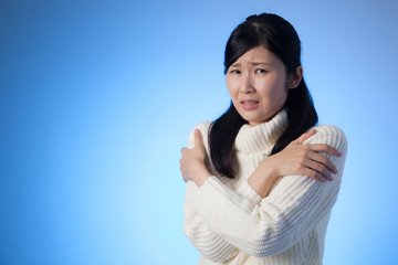 女性、ニット、寒い、震える、温める、青バック