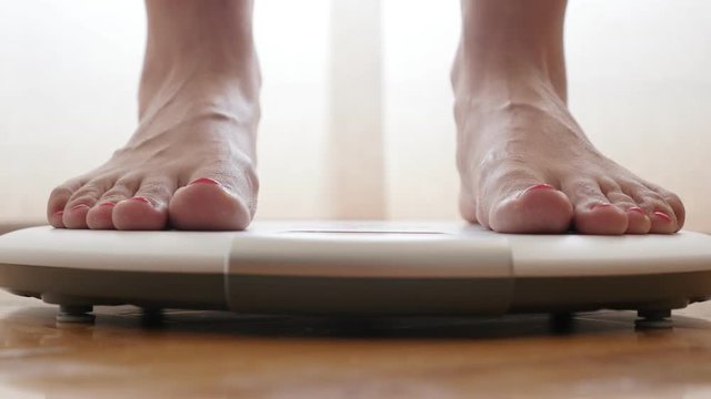 Female measuring weight on health scale close-up 4K 2160p 30fps UltraHD footage - Woman legs approaching to weighing digital instrument 3840X2160 UHD video 