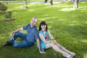 Couple sitting on the grass in the park  