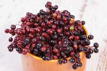 Bunch of fresh elderberry on old wooden background, healthy food