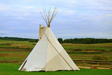 White wigwam on green field