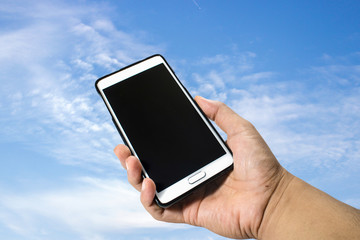 Hand hold smartphone on sky background