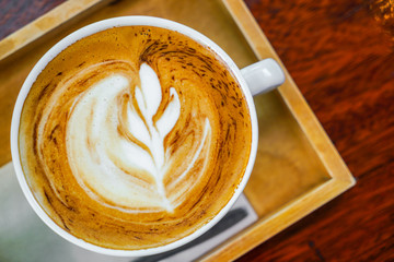 Latte Coffee art on the wooden table .