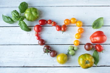 frische bunte Tomaten Tisch Holz Herz Kräuter Ernte