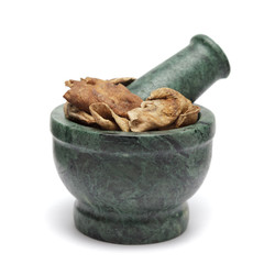 Organic Sour dried mango or Aamchur or Amchoor (Mangifera indica) on marble pestle. Isolated on white background.