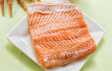 portions of fresh salmon fillet and vegetables