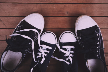 Old canvas shoes on a wooden floor Vintage Retro Filter.