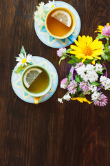 Two cups with tea on the wooden background