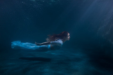 Fototapeta na wymiar Woman as the mermaid under water.