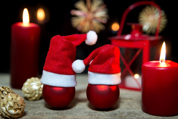 red christmas balls, candles and a lantern on wooden table