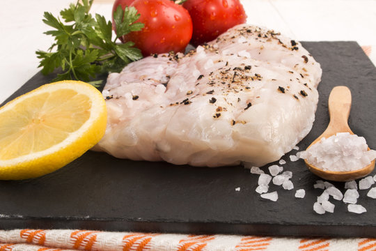 hake fillet with coarse sea salt, a slice of lemon, parsley and