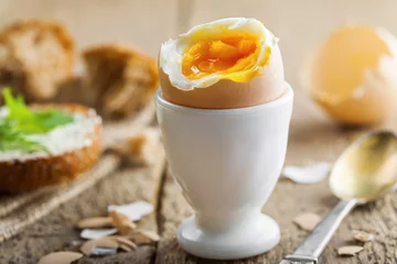 Foto op Aluminium Traditional breakfast with perfect soft boiled egg and sandwich with butter and dill. International cuisine food. © Maxim Khytra