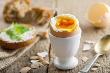 Abwaschbare Fototapete Perfect soft boiled egg with bread and butter for breakfast. Traditional healthy food. © Maxim Khytra