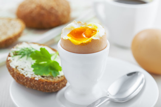 Perfect soft boiled egg, bread and butter with coffee for breakfast. Traditional healthy food.