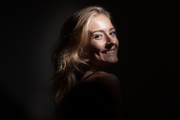 Naklejka premium Portrait of a beautiful blonde on a black background