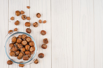 Hazelnut in a glass bowl on the old wooden table.