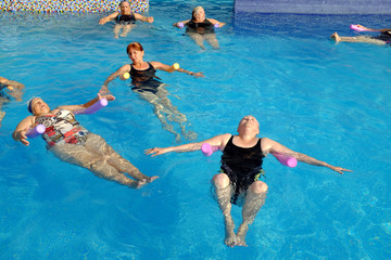Group of senior women doing exercise in pool.
