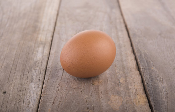 fresh raw egg on wooden table