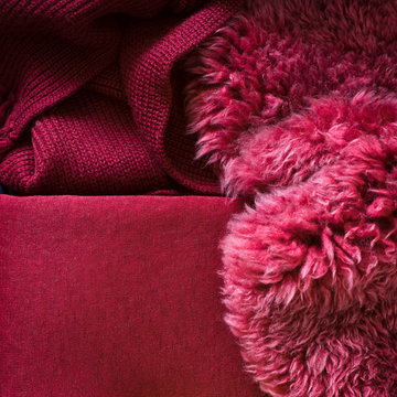 Cosy and warm textiles for fall decor: sheepskin and knitted blankets. Selective focus.