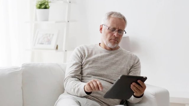 senior man with tablet pc at home 112