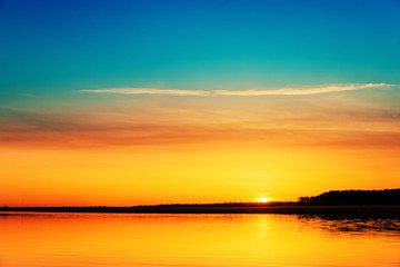 Fototapeta na wymiar bright orange sunset over river
