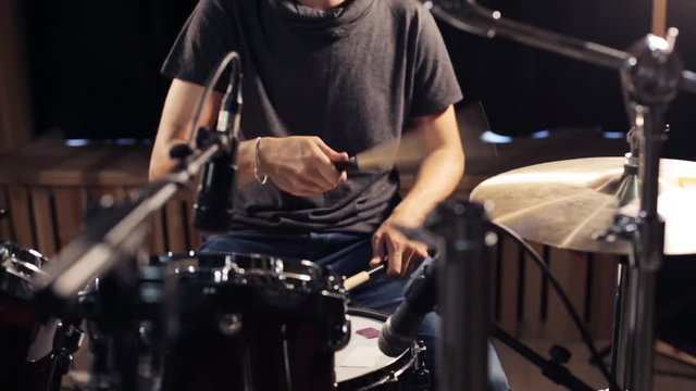 male musician playing drums and cymbals at concert