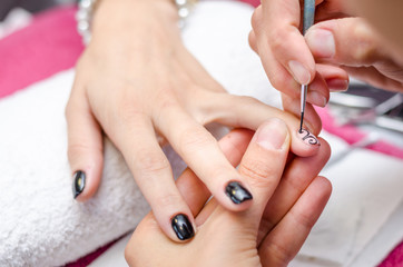 Woman applying black drawing nail polish
