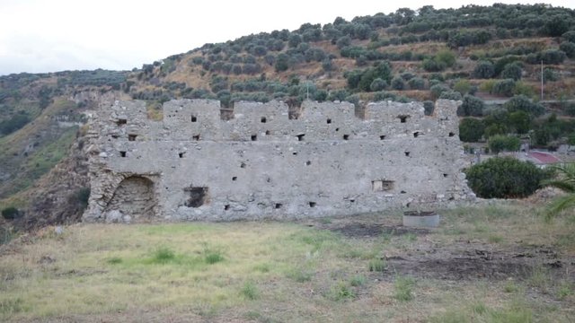 Antiche mura greche di un castello con Merli danneggiate. 