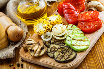 Set of grilled vegetables meal: tomato, corn, eggplant, mushroom, bell pepper, marrow and onion. Healthy organic food on a table.
