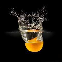 Fresh fruits falling in water with splash on black background