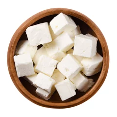 Poster Greek Feta cheese cubes in a wooden bowl on white background. Cubes of a brined curd white cheese made in Greece from milk of sheeps and goats. Crumbly aged cheese with slightly grainy texture. © Peter Hermes Furian