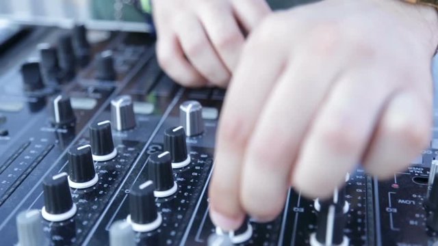 Mani del deejay sul mixer 
