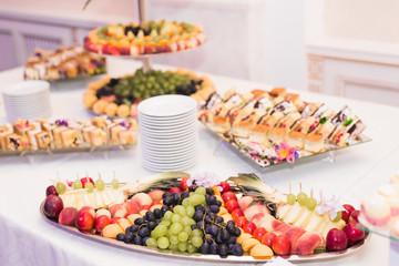 Delicious and tasty dessert table with cupcakes shots at reception closeup