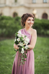 The beautiful woman, bride in pink dress with great bouquet