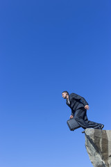 Jumping man with a diplomat from a cliff.