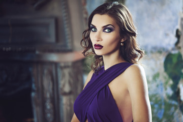 Beauty Brunette model woman in evening purple dress. Beautiful fashion luxury makeup and hairstyle.