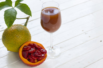 Green baby Jackfruit and juice on wooden white background.fruit for health and stillife