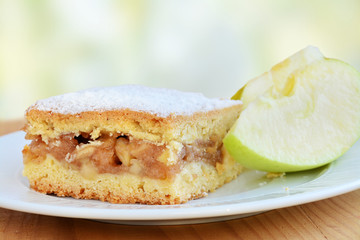 Apple pie square bar with cinnamon and powered sugar on white plate