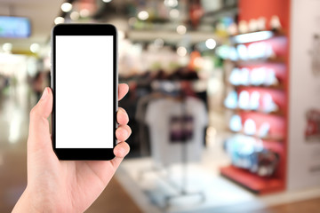 Fototapeta na wymiar Smart phone with white screen in hand on blurred in shopping mall background,shopping online concept,shopping by smart phone