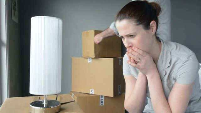 Upset woman (age 30-40) when her partner is move out from home. Moving house concept. Real people. copy space