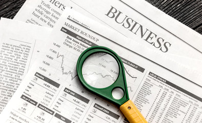 Magnifier with business newspaper on the table