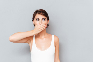 Young woman covering her mouth with palm