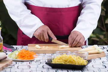 Chef cutting baby corn